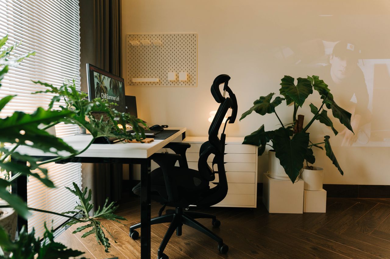 A stylish home office setup with plants and ergonomic chair, perfect for a productive work environment.